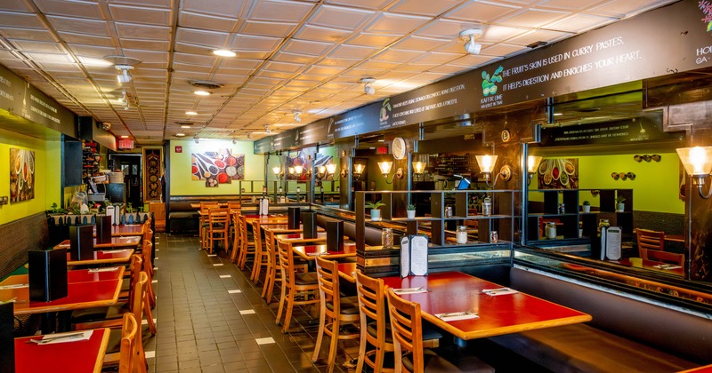 Interior - wooden tables and chairs, light green walls and food-themed artwork.