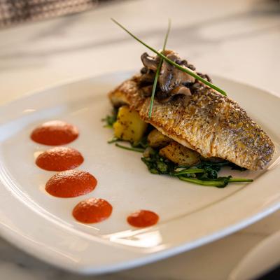 Roasted Black Bass, with potatoes, spinach, mushroom butter, and tomato puree.