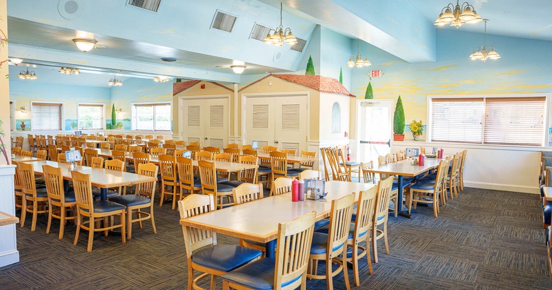 Large dining room with tables, chairs, murals