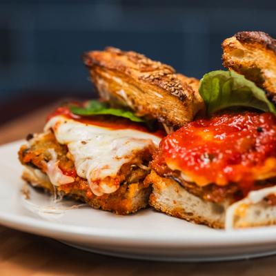 Eggplant Parmigiana served on a white plate, close up.