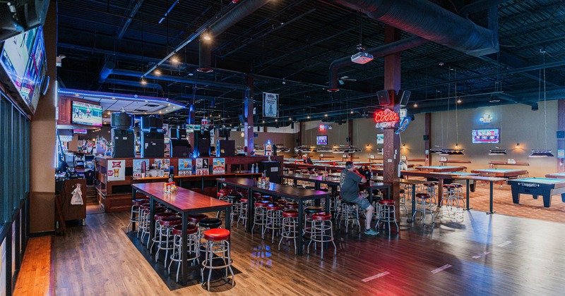 Interior, high seating area, long tables for fourteen, pool tables in the back