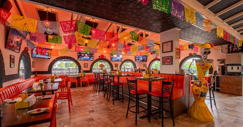 Interior of a lively Mexican-style dining area decorated with hanging paper ornaments