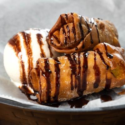 Chocolate chip cookie dough egg rolls with vanilla ice cream and chocolate drizzle.