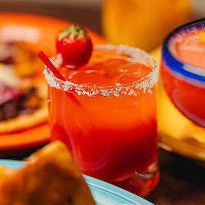 Close-up of a strawberry margarita with salted rim and strawberry garnish.