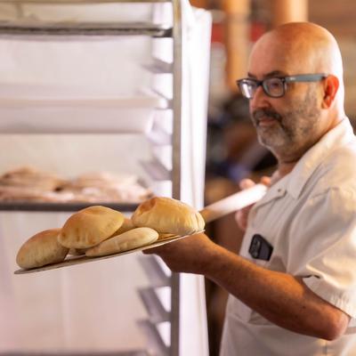 A person holding a tray with pastry.