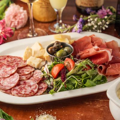 Antipasto plate, with pecorino, parmesan, prosciutto, salami, olives, lettuce, and tomato.