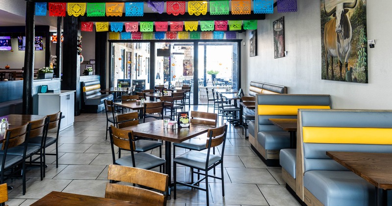 Interior seating area with wooden tables, chairs and booth seats