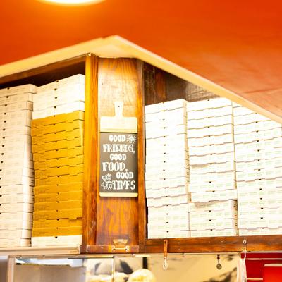 Interior, a storage area with stacks of pizza boxes.