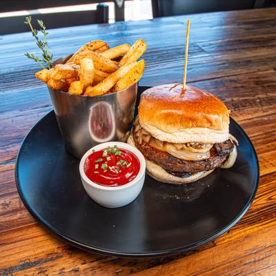 Burger served with fries and ketchup on a wooden table