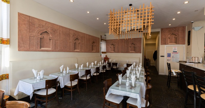 Spacious and cozy interior dining area with dining tables set for two guests