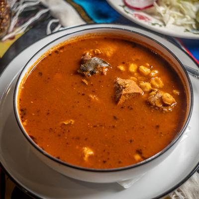 Bowl of Pozole soup with hominy and pork chunks.