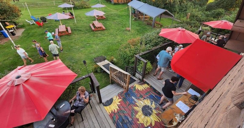 Outdoor seating space on a deck attached to a house and lawn in front