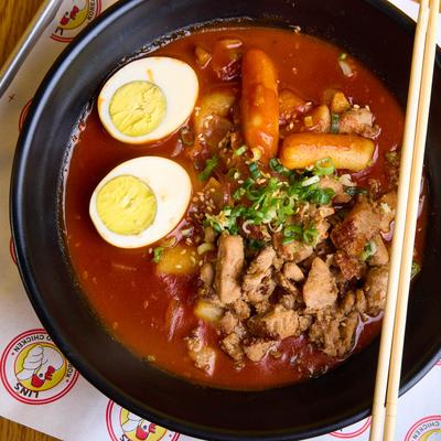 Spicy Korean stew with chicken, rice cakes, fish cakes, and an egg.