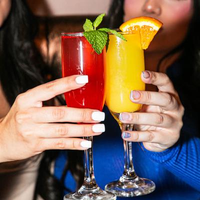 Two guests clink cocktail glasses in a toast.