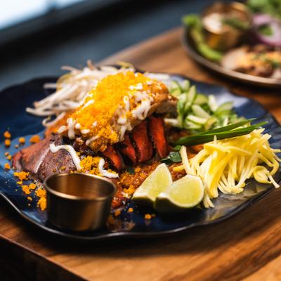 Saitong Pad Thai with a lobster tail, rice noodles, chives, bean sprout and shredded mango.