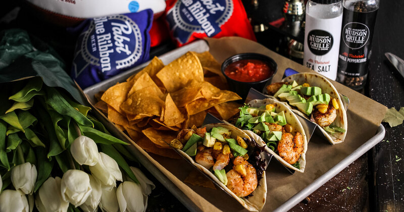 Three tacos, snacks and red dip on the side