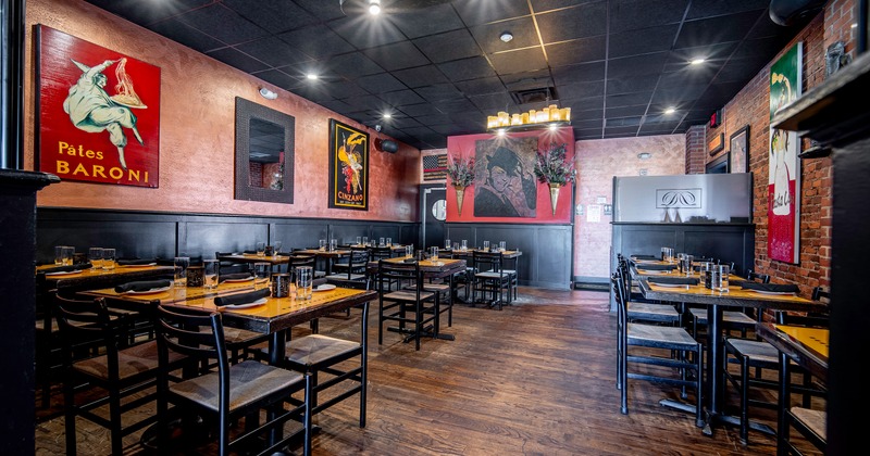 Spacious interior dining area with dining tables set with glasses, plates, and black napkins