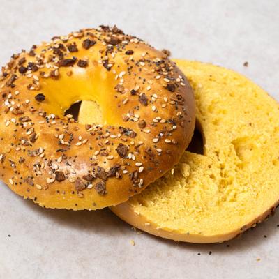 Egg everything bagel, sliced in half, closeup.