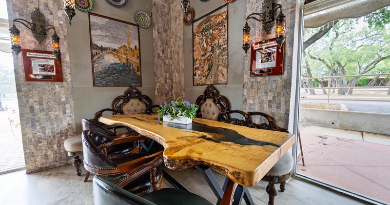 Large polished wooden table with vintage-style booth seats and dark leather chairs
