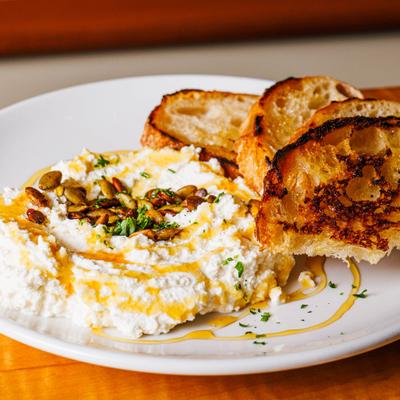 Whipped ricotta with toasted bread, pumpkin seeds, and honey drizzle.
