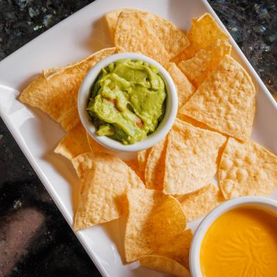 Tortilla chips , guacamole and Mexican cheese dip. top view