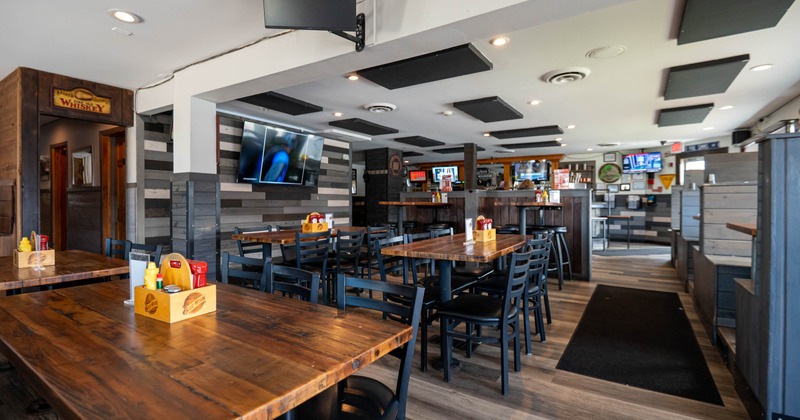 Interior, wide shot of the dining room, wooden top tables for four, high and regular seating