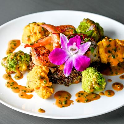 Scallops with cauliflower, quinoa, and a purple orchid.