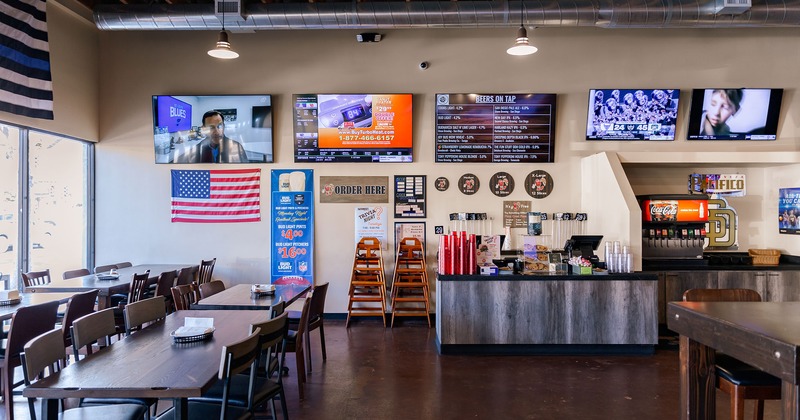 Interior, order counter with TVs on the wall, and dining tables