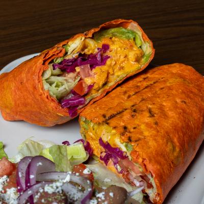 Grilled chicken wrap with lettuce, cheese, tomato, pickled red cabbage, and a side salad.