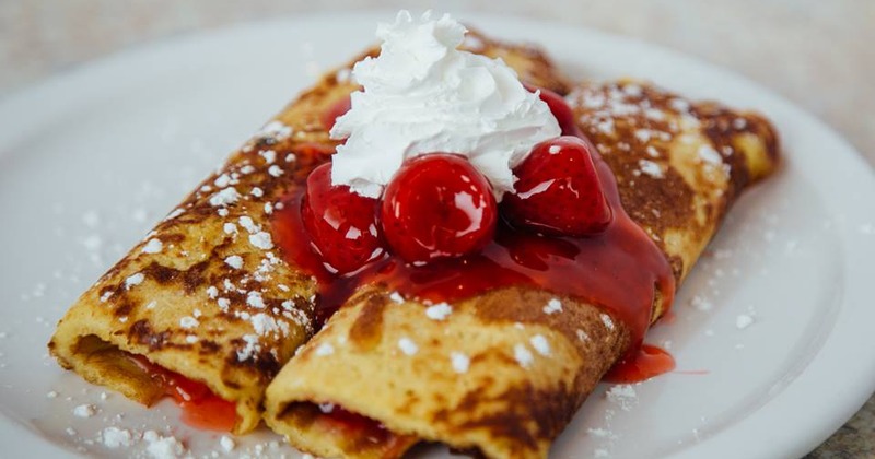 Cherry crepes topped with cherry sauce and whipped cream