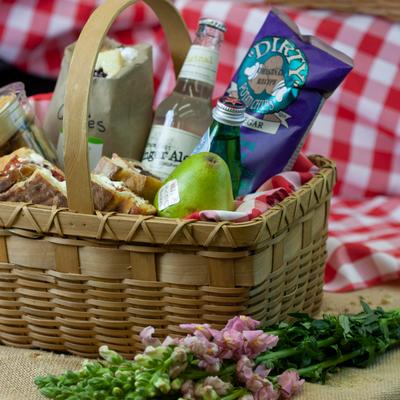 Willow wicker basket filled with various snacks and drinks.