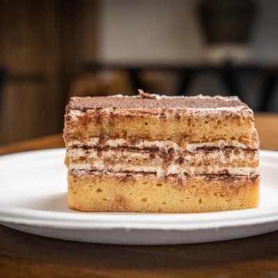 A slice of tiramisu on a white plate.