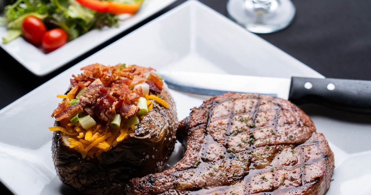 Grilled steak served with a loaded baked potato
