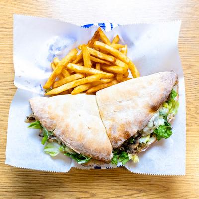 Cheesesteak sub served with fries.