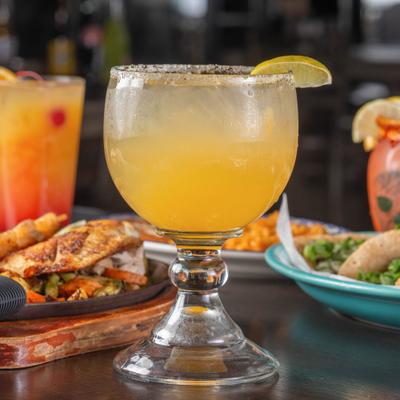 Margarita cocktail served on the table alongside food items.
