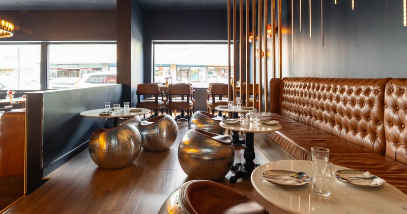Interior seating area with leather seating, marble tables, and metallic stools