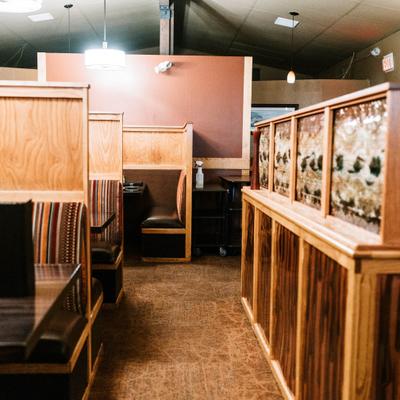 Restaurant interior with wooden booth seating and striped upholstery.
