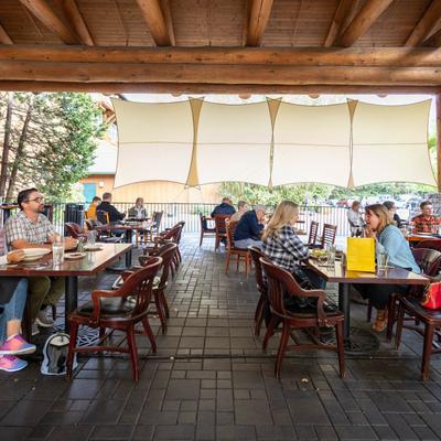 Covered outdoor seating area with guests dining
