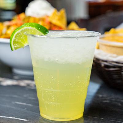 Lime Margarita served on  a dark table with food dishes.