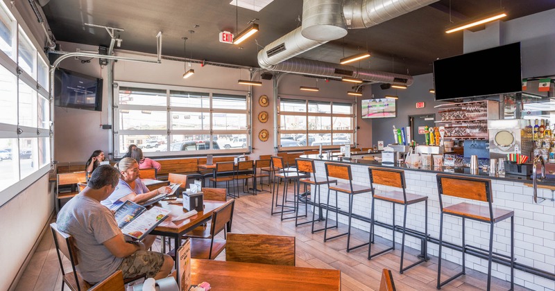 Interior, dining area, guests dining, the bar with chairs and a large wall TV screen