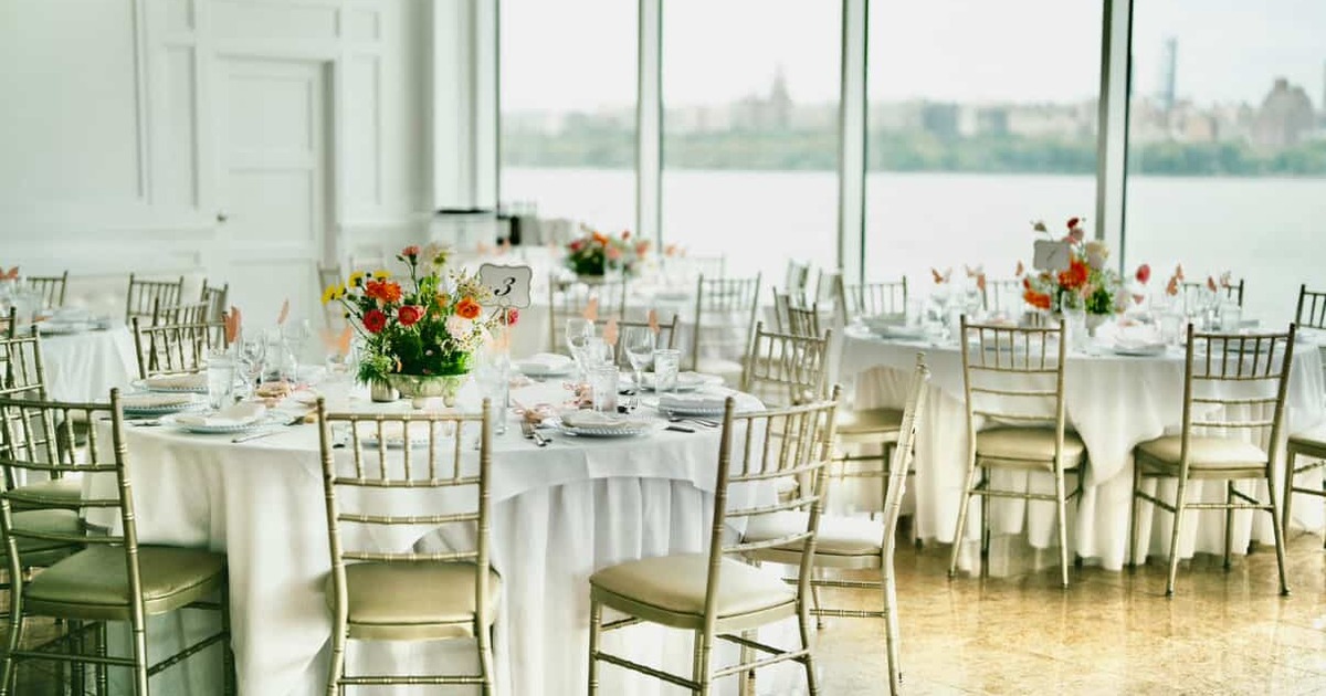 Waterfront banquet tables set with colorful floral centerpieces