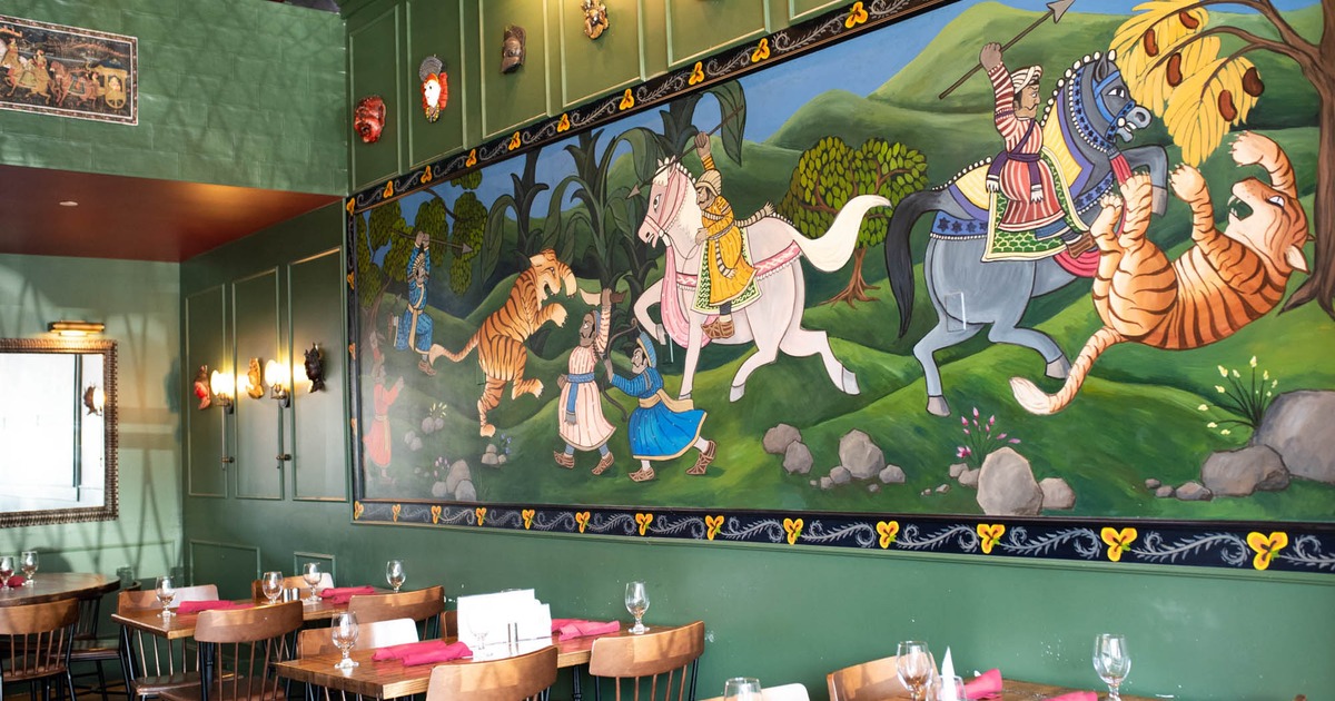 Interior, guest tables and chairs ready for guests, mural on the wall