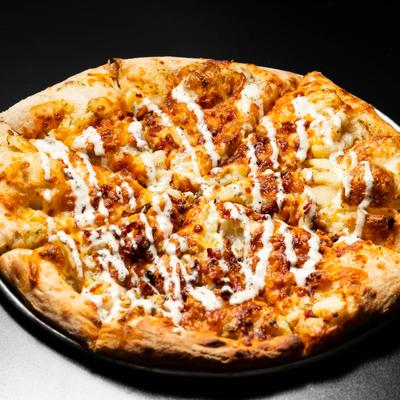 Loaded Baked Potato Pizza drizzled with sauce.