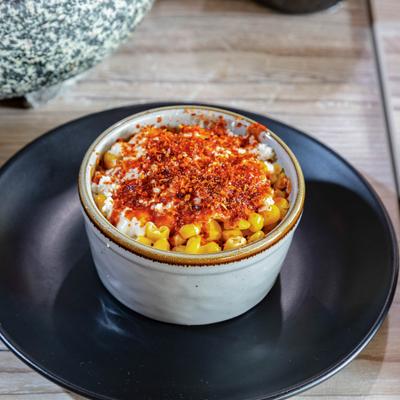 Street corn kernels topped with butter, mayonnaise, cheese, and tajin.