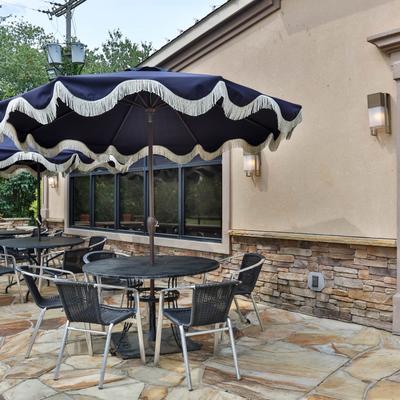 An outdoor patio area with tables, chairs, and umbrellas.