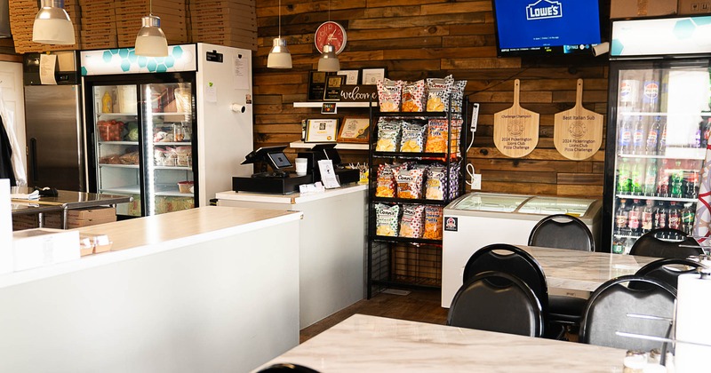 Interior, dining area, tables with chairs for four, checkout counter, wood coated walls