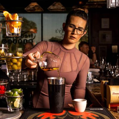 A person preparing a cocktail.