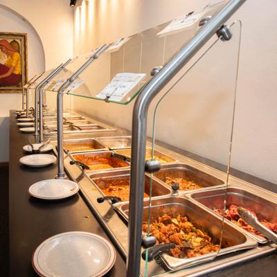 Buffet setup featuring various dishes in heated serving trays.
