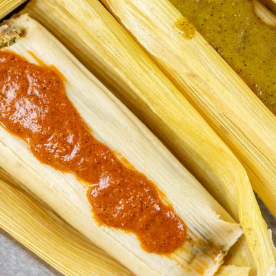 Pork tamales with sauce on top, top view