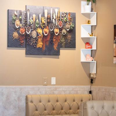 Interior with spice-themed wall art and partial view of leather booth benches.